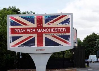 A man photographs a sign in Manchester, Britain May 23, 2017. REUTERS/Stefan Wermuth