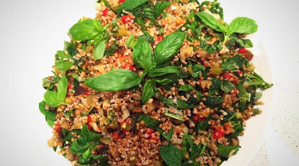 A traditional Turkish bulgur salad garnished with fresh herbs and tomatoes