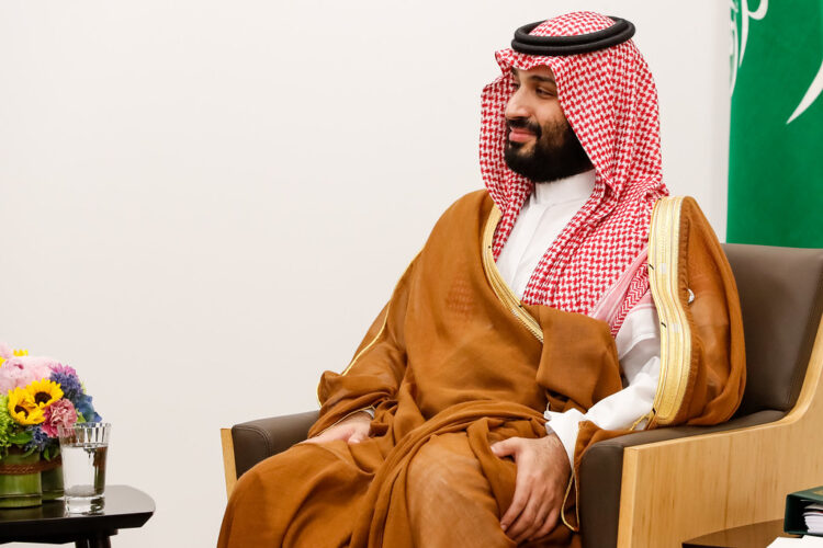 a man in a brown robe sitting in a chair