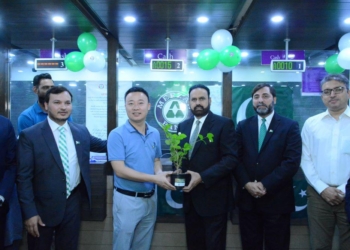 a group of men holding a plant