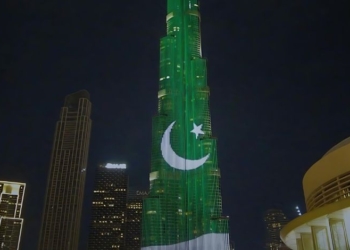 a tall building with a green and white moon and star